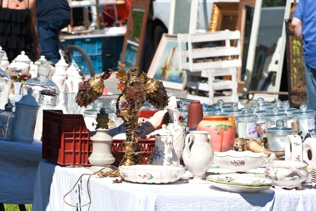 Used items for sale on the table of a flea market.