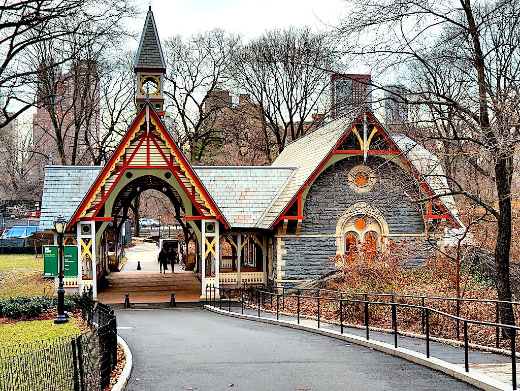 A view of the visitor center in central Park ona. cold winter's day. It is made of wood and has a steeped roof with gray and brown siding on the building. 