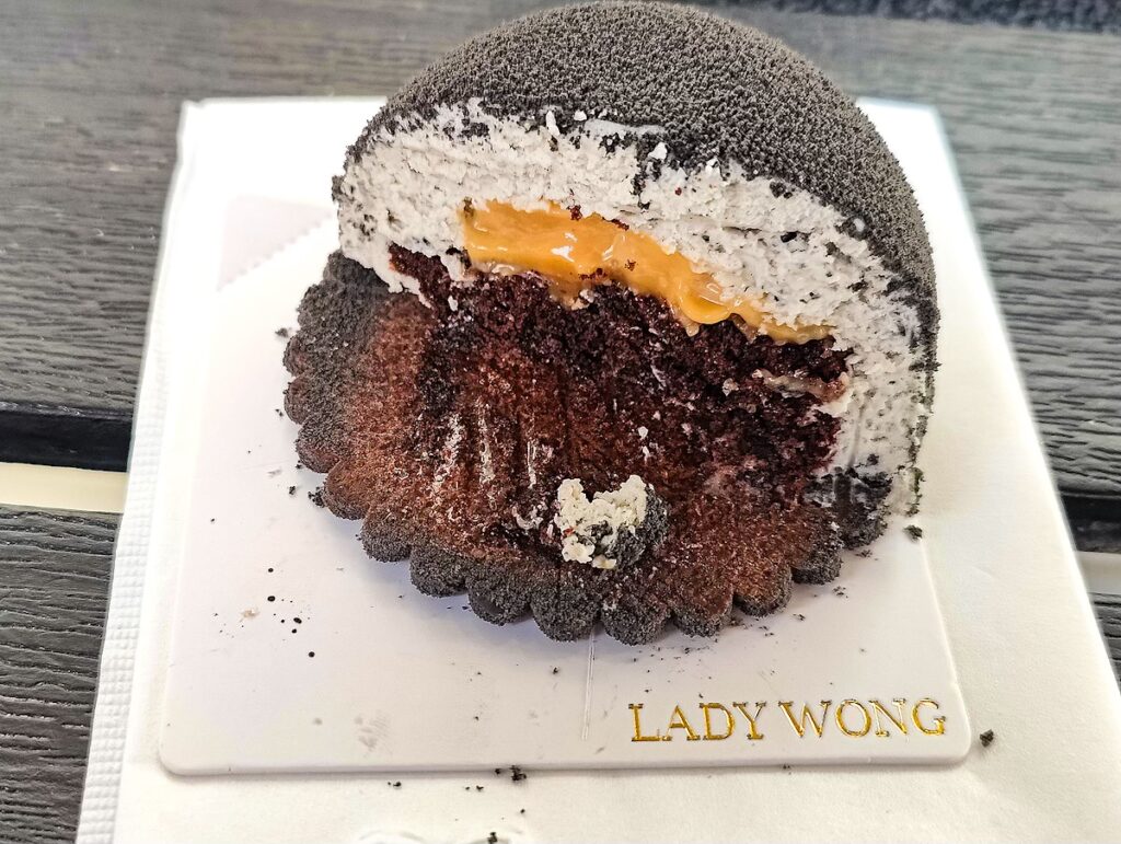 Interior of the black sesame dessert from Lady Wong's You can see a yellow passion fruit cream as well as chocolate and white cream layers. You can find this dessert at one of the best bakeries in NYC. 