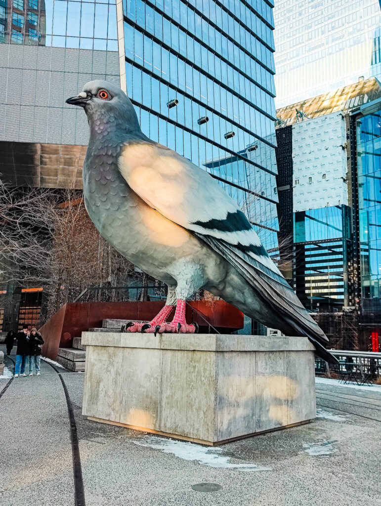 View of a giant pigeon statue sitting along the Highline in NYC. 