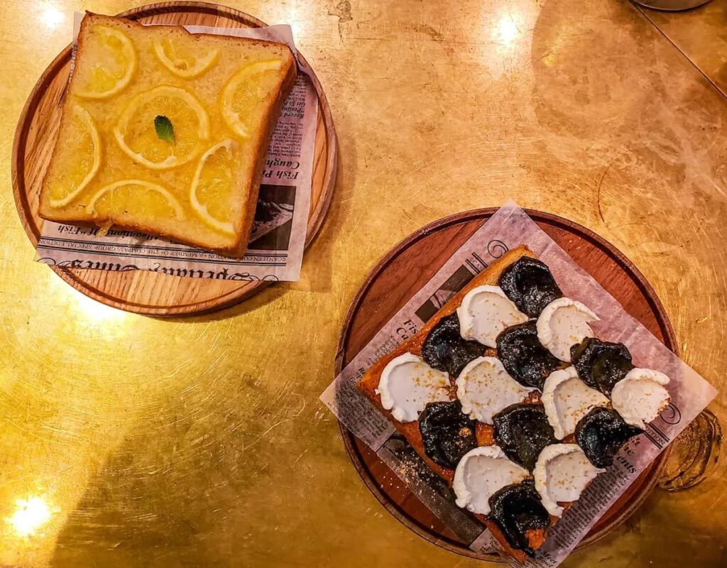 Aerial view of toast made with lemon slices and a black and white toast made with cream and jam from Davella. They serve the best breakfast in NYC. 